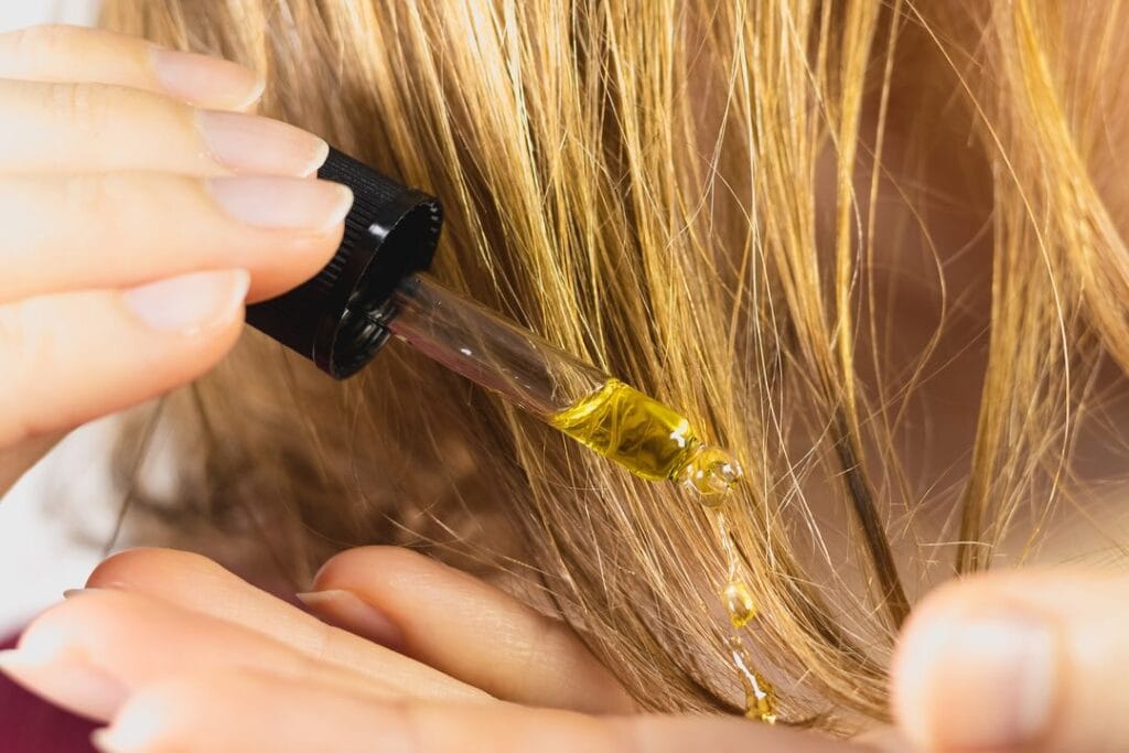 femme applique un serum sur les pointes