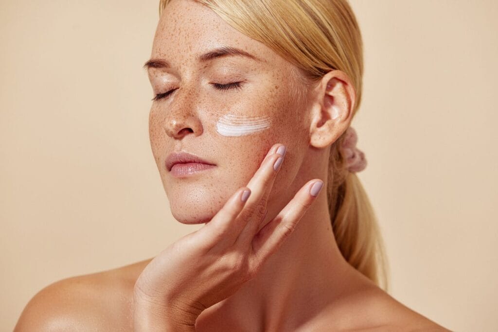 femme qui applique de la creme hydratante sur son visage pour fixer l'acide hyaluronique
